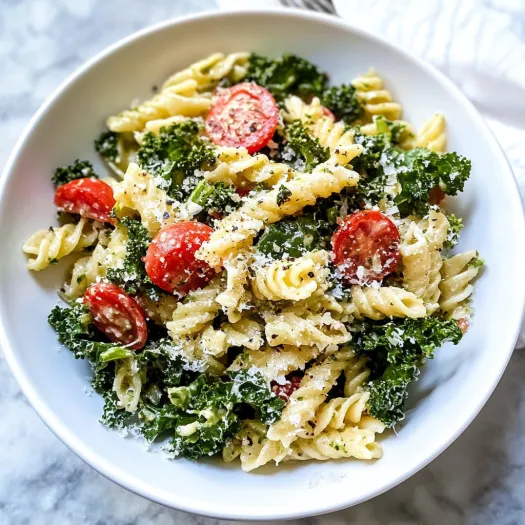 A bowl of pasta salad with kale and tomatoes.