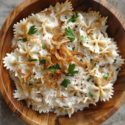 Un bol cu salată de paste cu ceapă caramelizată.
