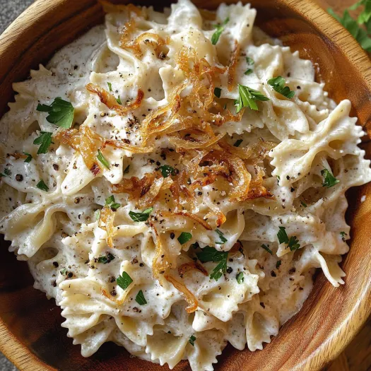 Un bol cu salată de paste cu ceapă caramelizată.