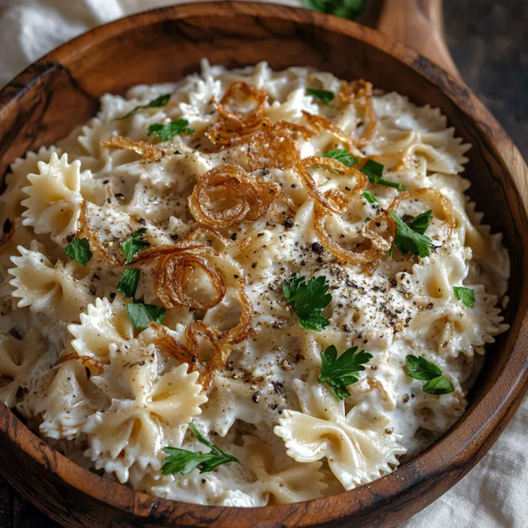 Bol cu paste și ceapă caramelizată.