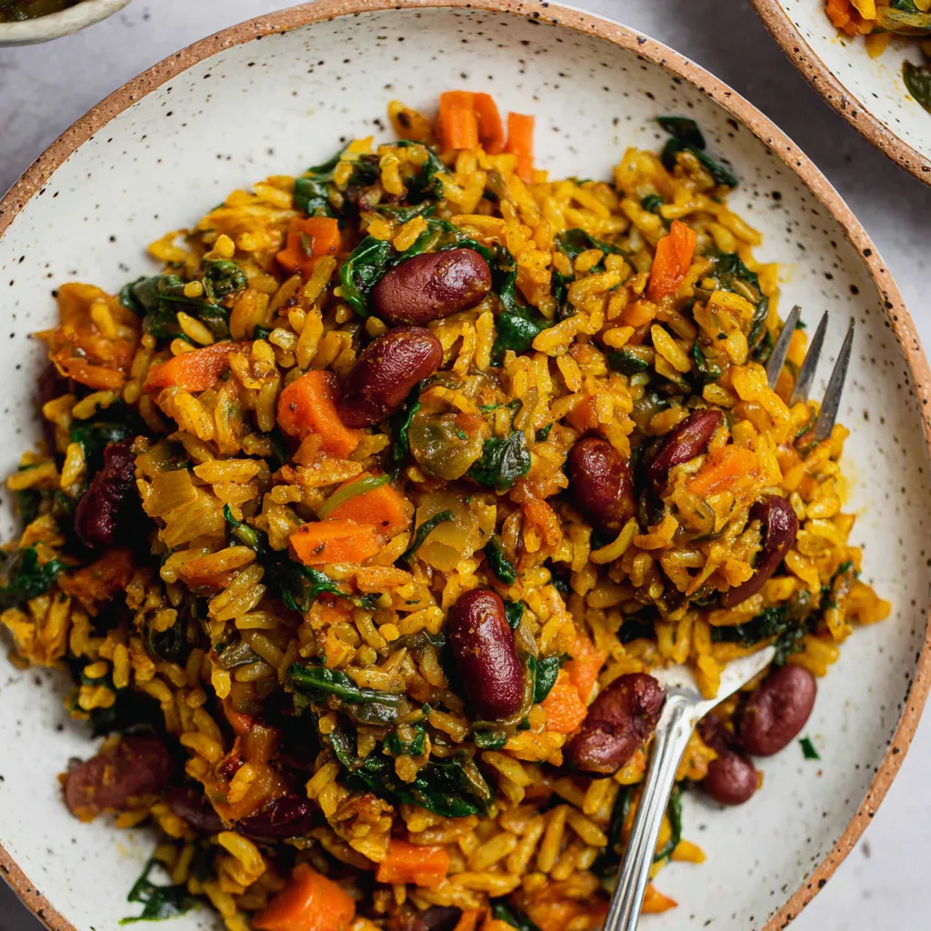 A plate of rice with beans and spinach.